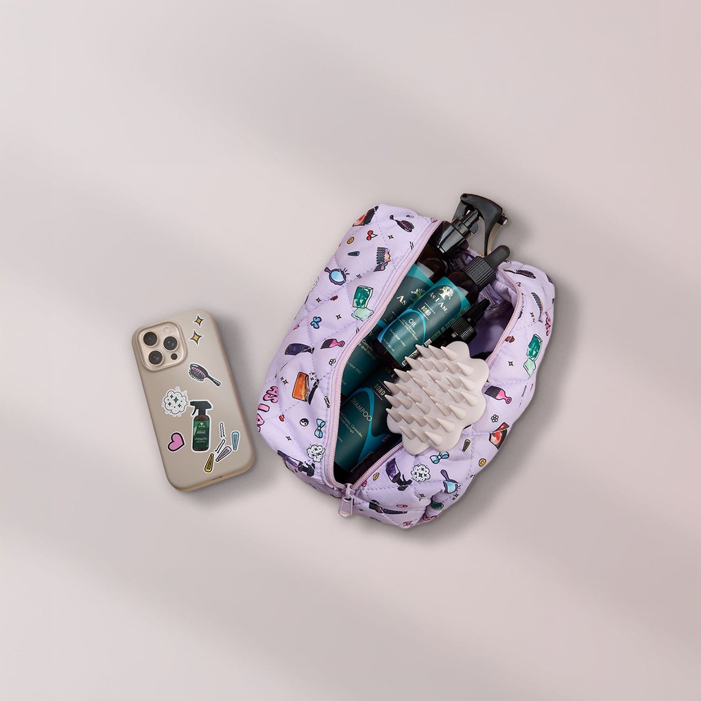 Brosse à cheveux beige dans un sac cosmétique avec des produits de soin et un téléphone