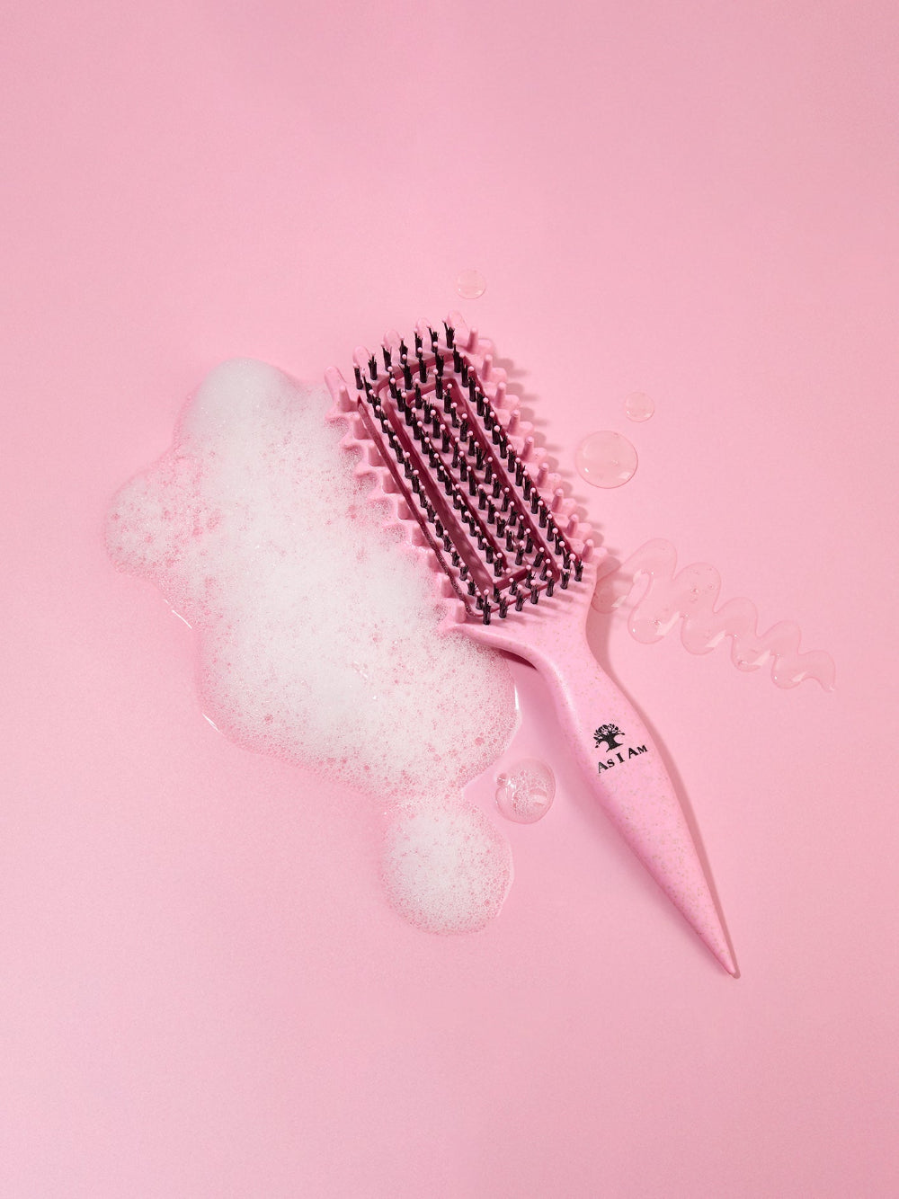 Brosse à cheveux rose avec poils sur fond rose