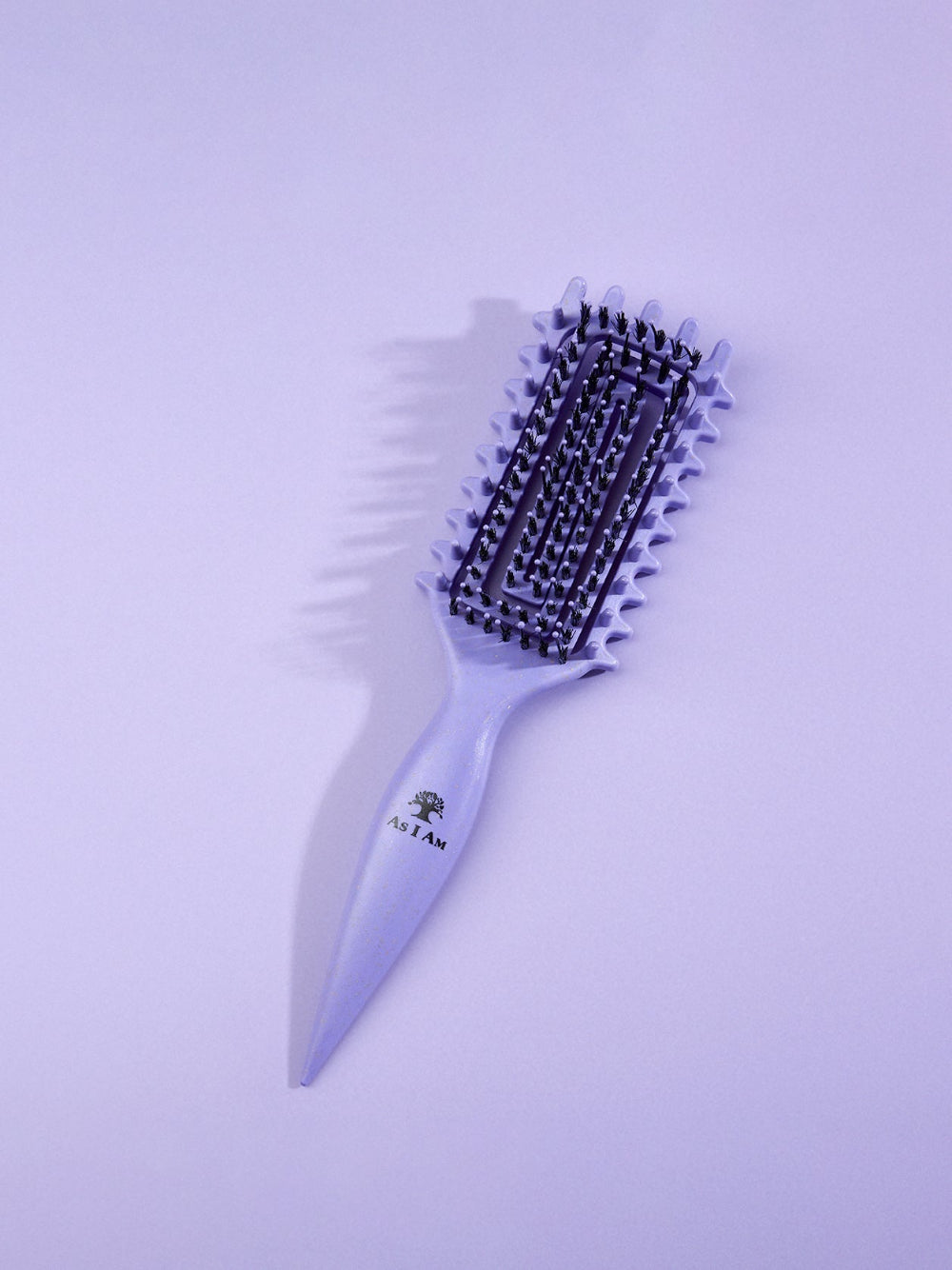 Brosse à cheveux violette avec tête en poils sur fond violet clair