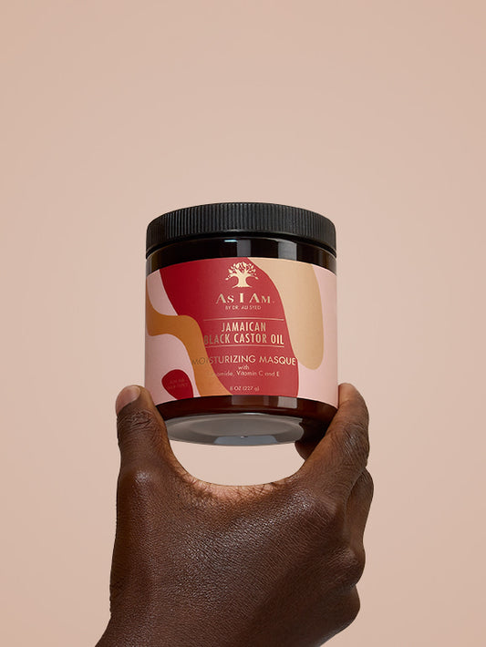 Masque capillaire à l'huile de ricin noire jamaïcaine As I Am - portrait du traitement revitalisant en profondeur tenu dans la main, mettant en évidence la formule riche et réparatrice conçue pour renforcer et hydrater les boucles naturelles grâce à l'huile de ricin noire jamaïcaine (JBCO).