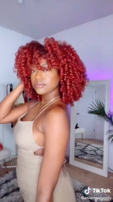 Kimberly Cherrell portant As I Am Curl Color - présentant des boucles vibrantes et définies, coiffées avec un gel de coloration temporaire, mettant en valeur un pigment audacieux et une brillance saine.