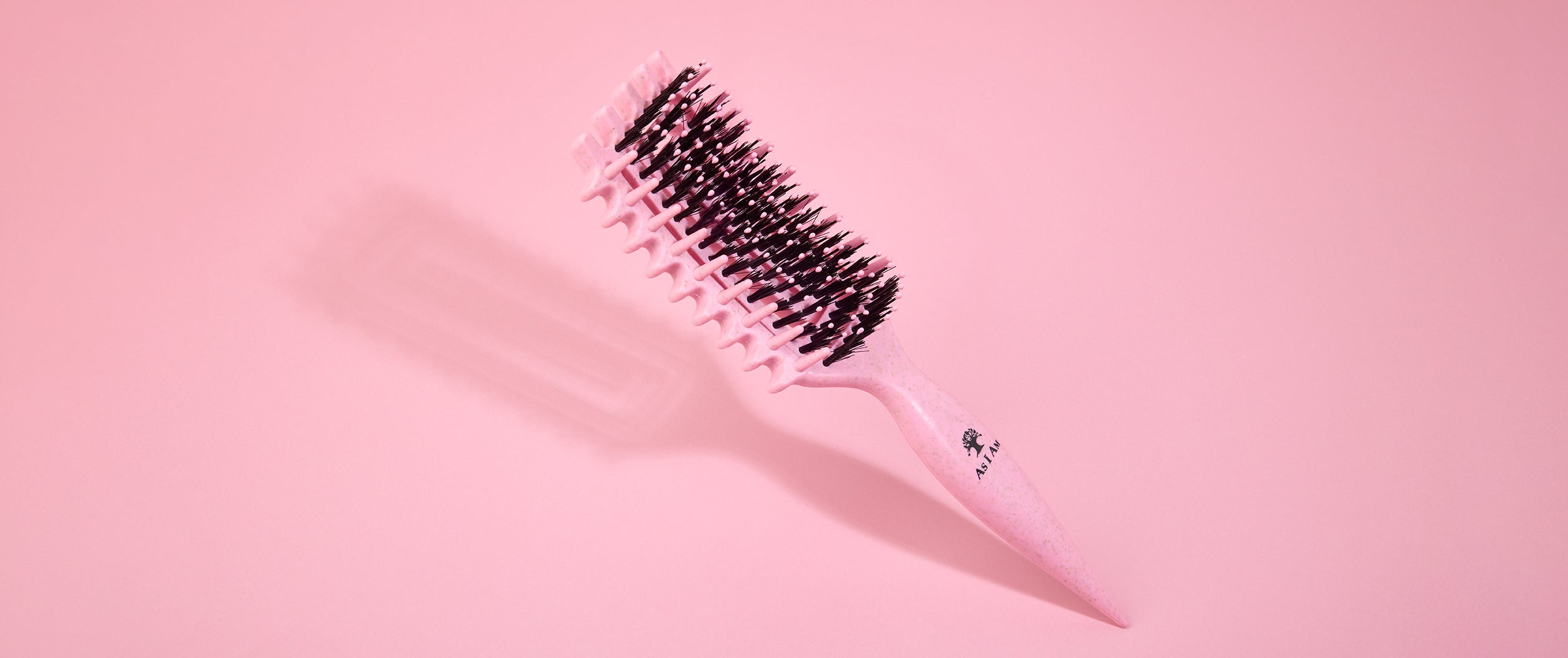 Brosse à cheveux sur fond rose