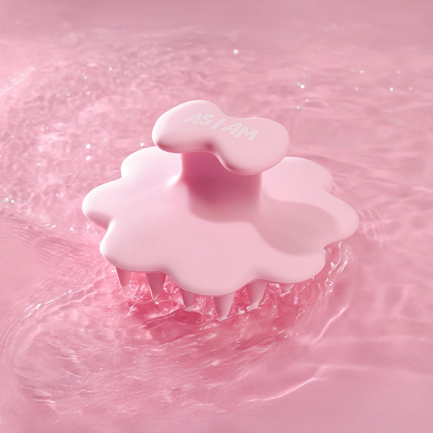Brosse à cheveux rose sur fond d'eau rose