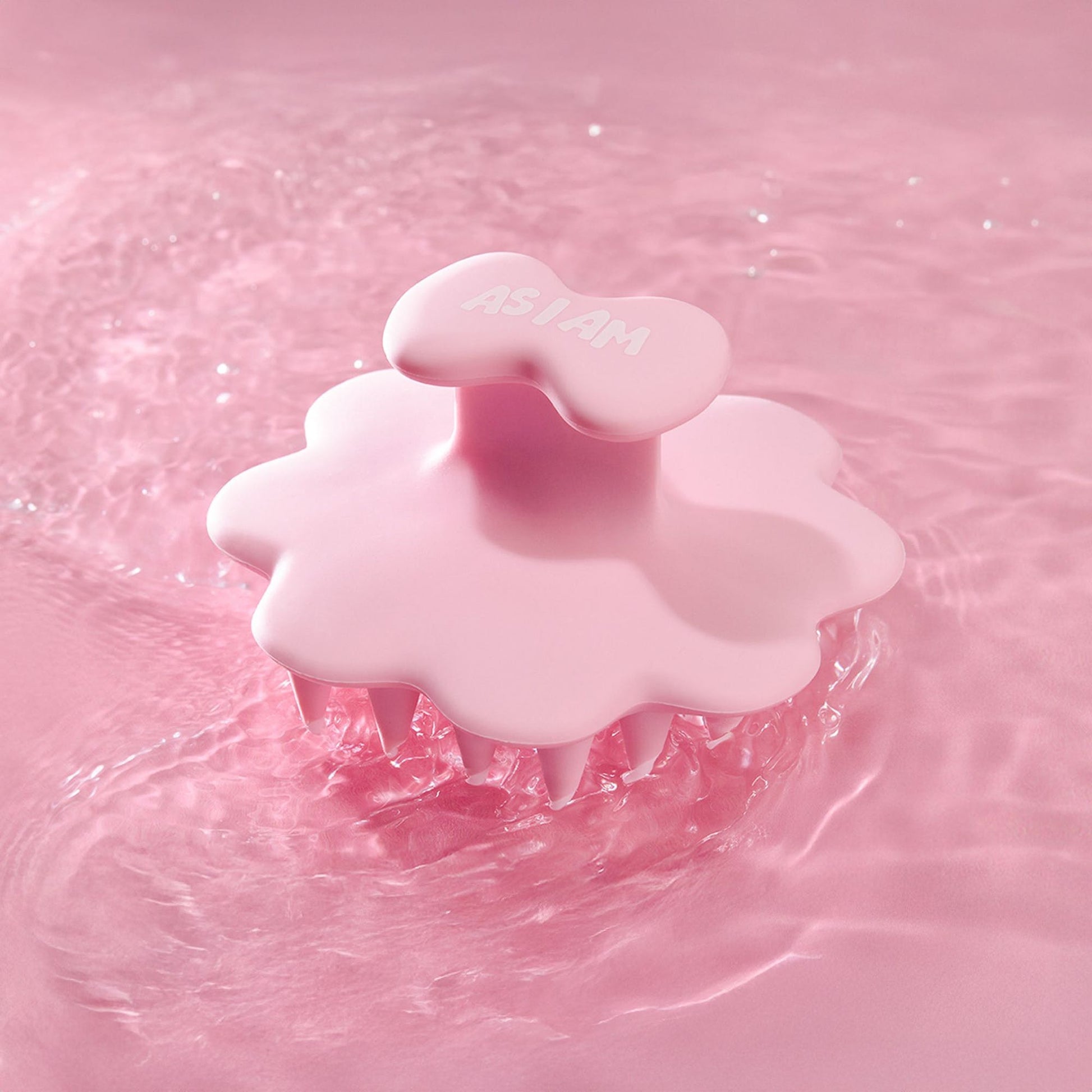 Brosse à cheveux rose sur fond d'eau rose