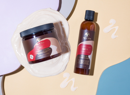 Deux produits capillaires, un pot et un flacon, sur fond beige avec des éléments décoratifs.