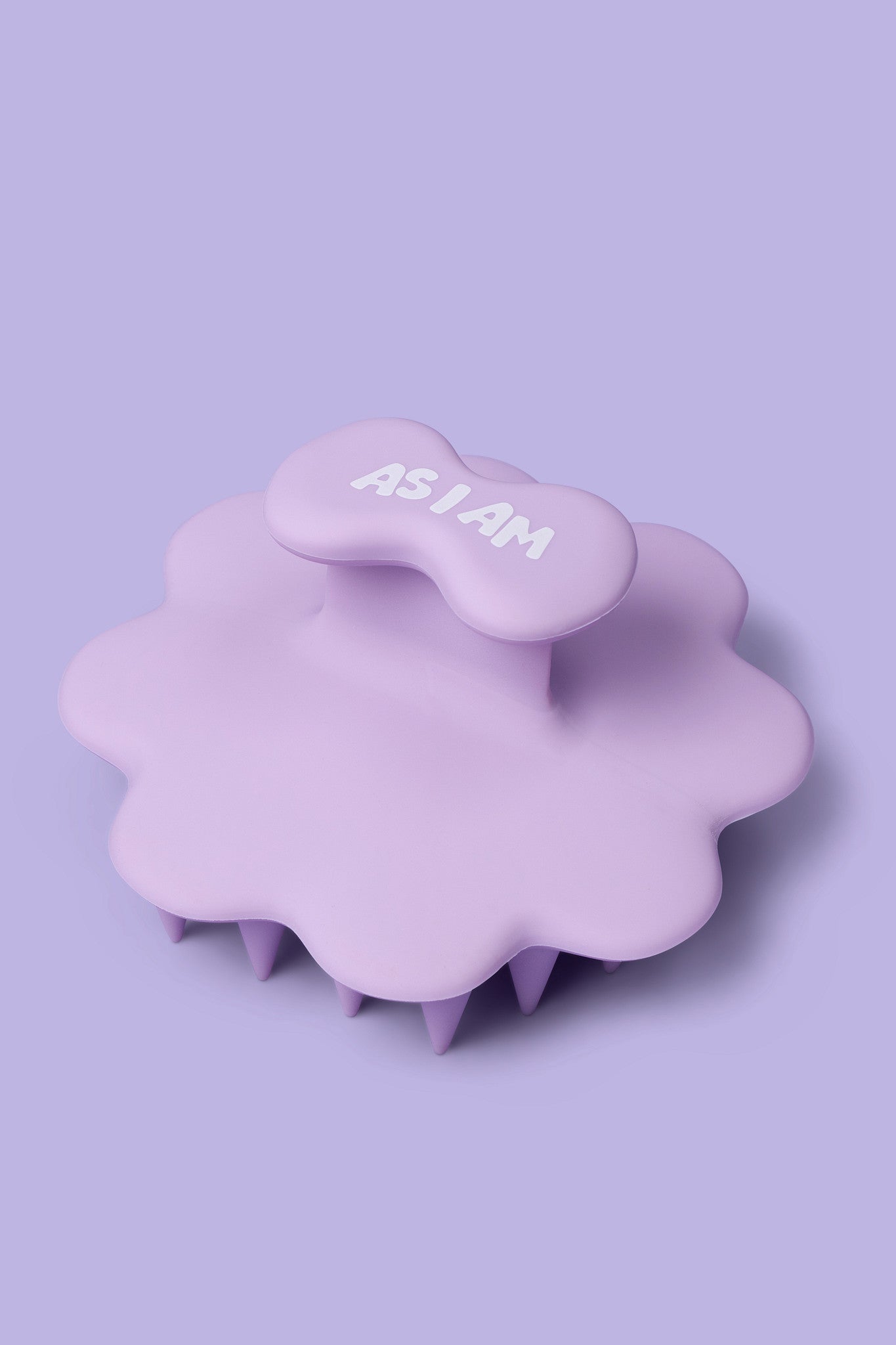 Appareil de massage du cuir chevelu violet avec l'inscription « AS I AM » sur fond violet clair