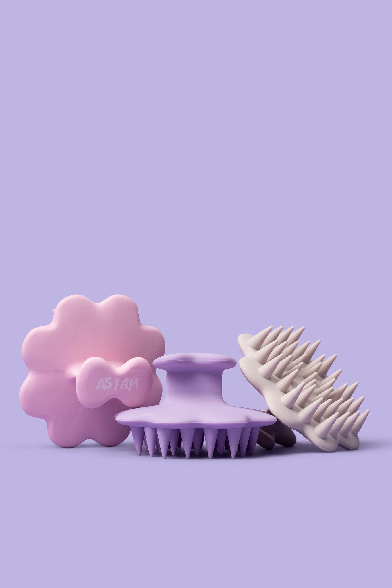 Trois outils en silicone avec des motifs floraux, ronds et pointus sur fond violet